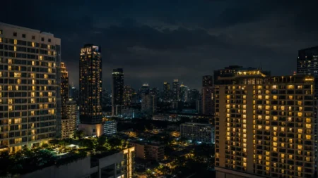 東南アジアの都市の夜景、高層ホテルの窓明かりが立ち並ぶ緊迫感のある情景