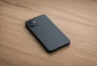 木製デスクに画面を伏せて置かれたスマートフォンのイメージ