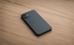 木製デスクに画面を伏せて置かれたスマートフォンのイメージ