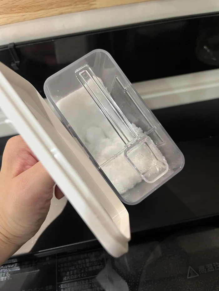 画像 砂糖を入れた容器の中ですり切り板を使って計量したところ