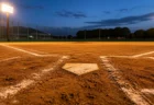 夕方のナイター照明に照らされた高校野球のホームベース付近