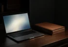 暗い部屋でノートPCの画面が発する柔らかな光と書類ファイル