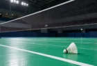 照明に照らされたバドミントンコートとネット際のシャトル