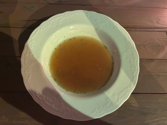 白いスープ皿に入った澄んだスープ