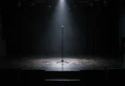照明が落ちたライブハウスのステージに1本だけ立つマイクスタンドとスポットライト