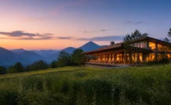 北海道の山々を望む高原に建つ夕暮れのモダンなリゾートホテルのイメージ
