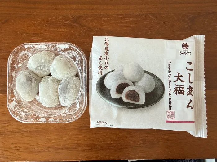 透明のトレーに入ったひとくちこしあん大福とパッケージを並べた様子