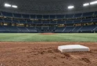 ドーム球場の内野の土と二塁ベース、背景に無人のマウンド