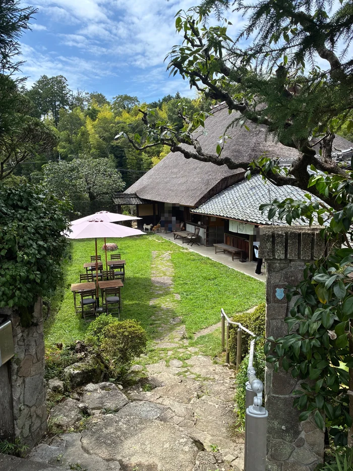 画像 入口から見たはなとねの茅葺き屋根の母屋と芝生の庭