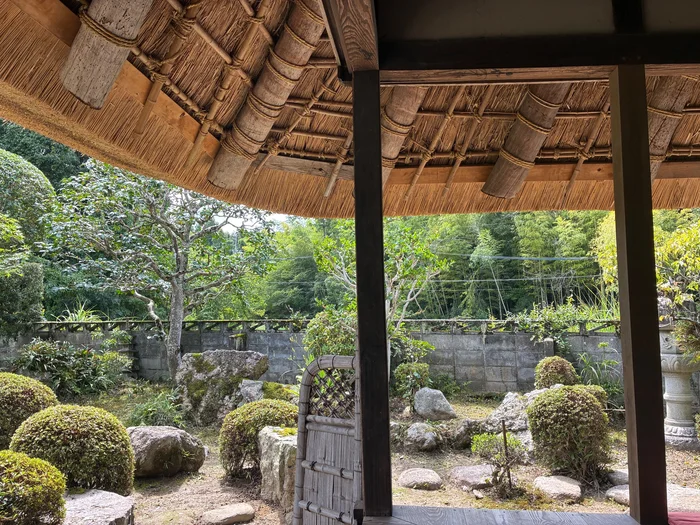 画像 はなとねの縁側の柱越しに見える茅葺き屋根と庭