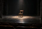開演前の小劇場の舞台にひとつ置かれた木の椅子とスポットライト