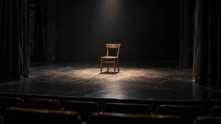 開演前の小劇場の舞台にひとつ置かれた木の椅子とスポットライト