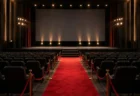 映画館のレッドカーペットと舞台挨拶用のステージ照明、無人の客席