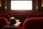 上映前の映画館の赤い客席。肘掛けに海苔を巻いたおにぎりと無地の半券