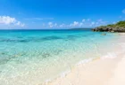 晴れた日の宮古島の海岸線と、エメラルドグリーンの浅瀬が広がる写実的な風景