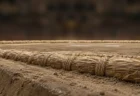 相撲の土俵の俵と土の表面のクローズアップ。背景はぼけた無人の観客席