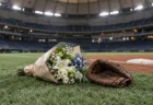 試合後のドーム球場、一塁ベース付近に置かれた花束と一塁手用ミット
