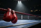スポットライトに照らされた無人のボクシングリングと赤いグローブ