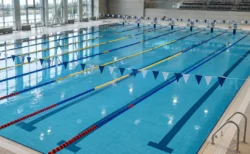 背泳ぎ用のフラッグが張られた屋内競泳プールの水面とレーンロープ