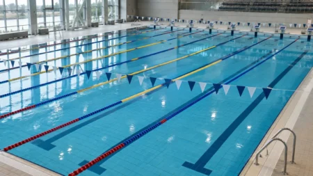 背泳ぎ用のフラッグが張られた屋内競泳プールの水面とレーンロープ