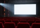 上映前の映画館の赤い客席と光るスクリーン