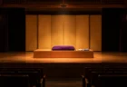 開演前の小劇場の舞台に置かれた高座の座布団と扇子