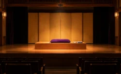 開演前の小劇場の舞台に置かれた高座の座布団と扇子