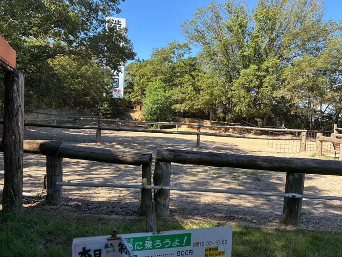 画像 木の柵で囲まれた乗馬コースと渋川動物公園の広告塔
