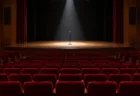 スポットライトが当たるセンターマイクと開演前の無人の客席