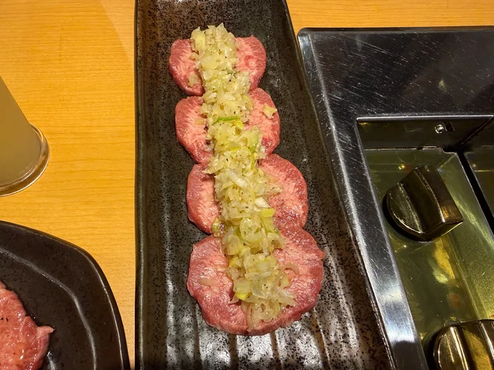 細長いお皿に並んだタンの上に刻みネギをのせた一皿