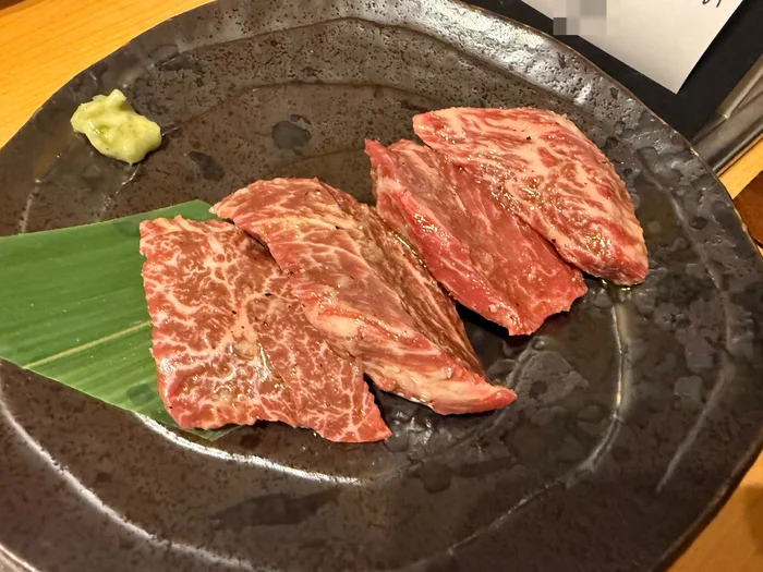わさびと竹の葉が添えられた、サシの入った焼く前の上ハラミ