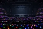 暗いアリーナのステージとペンライトの光