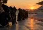 夕方の光に照らされたサーキットのピットレーンとレーシングバイク
