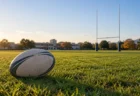 秋の晴れた日の高校のラグビーグラウンドに置かれた楕円球とゴールポスト