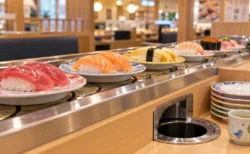 回転寿司のレーンを流れる寿司皿と、テーブル席の皿投入口
