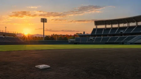 秋の夕方、大学野球の神宮球場を思わせるスタジアムの内野と外野スタンド