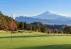 富士山を望む秋のゴルフ場のグリーンとピンフラッグ