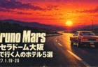 Bruno Mars 京セラドーム大阪 車で行く人のホテル5選 2027.1.19-20の文字と、夕焼けの高速道路を走るクラシックカーを描いた昔のロードムービー風ポスター