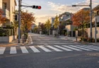 秋の午後、街路樹が色づく住宅街の静かな交差点と横断歩道