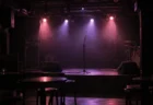 照明を落とした無人のライブハウスのステージとマイクスタンド