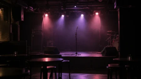 照明を落とした無人のライブハウスのステージとマイクスタンド