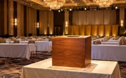 ドラフト会議を思わせる会場の長机と、照明に照らされた抽選箱