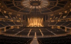 照明が落とされた開演前の大きなアリーナのステージと客席