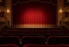 赤い緞帳が下りた開演前の劇場の客席