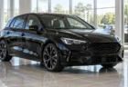 明るい自動車ディーラーのショールームに置かれた黒いスポーツハッチバック