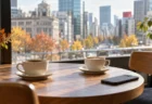カフェのテーブルに置かれた2つのコーヒーカップとスマートフォンのイメージ（AI生成）
