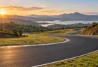 アフリカの丘陵地帯と湖を背景にカーブするサーキットのアスファルトコースのイメージ