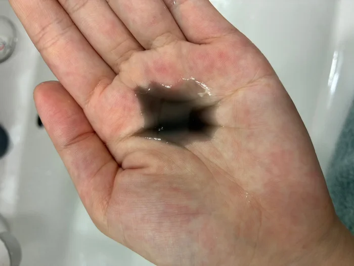 画像 手のひらに出した黒いクレンジングオイル