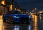 夜の港の倉庫街に止まる青いスポーツカーのシルエット