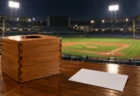 照明に照らされた抽選箱と、背景にぼやけたプロ野球の球場の夜景